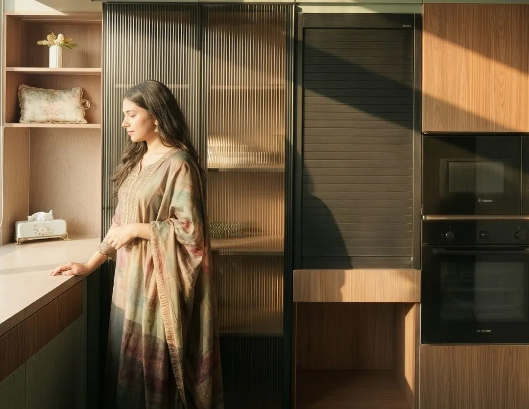 Homeowner in a SALT kitchen with olive cabinetry, fluted glass and tambour unit