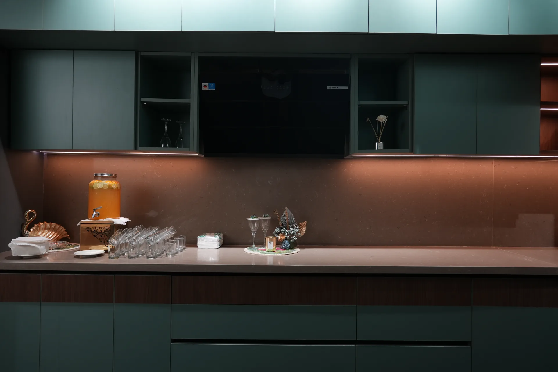 SALT modular kitchen with sage green cabinets, copper backsplash and under-cabinet lighting
